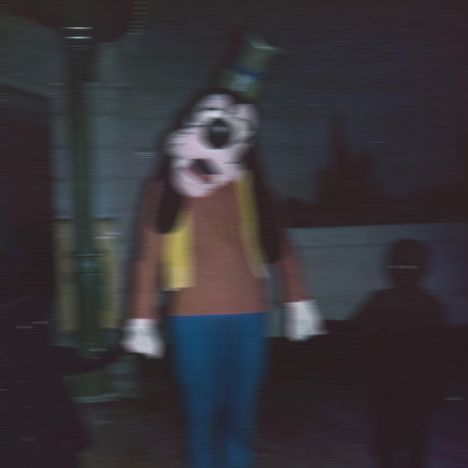 Es gibt keine erkennbaren Texte. Eine unscharfe Figur im Kostüm eines bekannten Charakters steht in dunkler Umgebung.