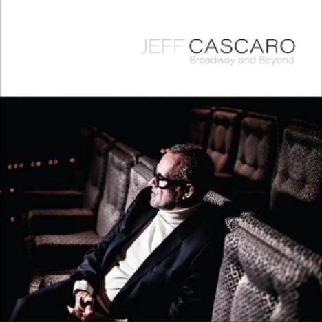 „Jeff Cascaro, Broadway and Beyond“ steht oben. Ein Mann sitzt in einem leeren Theater und trägt einen Anzug.