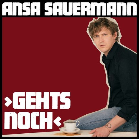 „ANSA SAUERMANN, GEHTS NOCH“. Dunkelroter Hintergrund, Person in Jeans und schwarzem Hemd sitzt neben einer Tasse Kaffee.