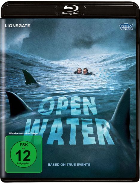Texte: "LIONSGATE", "Open Water", "Based on true events", FSK 12. Zwei Menschen treiben im Meer, von Haifischflossen umgeben.