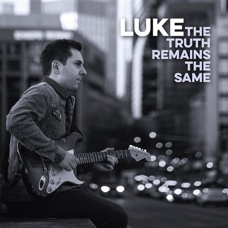 Text: "LUKE THE TRUTH REMAINS THE SAME". Ein Mann spielt Gitarre, sitzt in einer Stadtlandschaft, schwarz-weiß gehalten.