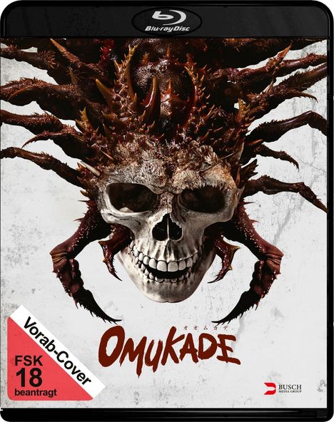 Text: "OMUKADE", "FSK 18 beantragt", "Vorab-Cover". 

Das Cover zeigt einen Totenkopf kombiniert mit einem monströsen, spinnenartigen Wesen.