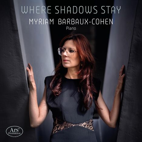 "WHERE SHADOWS STAY" und "MYRIAM BARBAUX-COHEN Piano". Frau mit langen Haaren in schwarzem Kleid zwischen zwei Wänden.