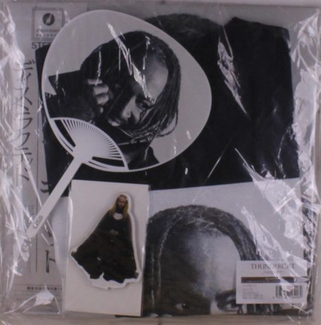 Ein Fächer mit einem schwarz-weißen Porträt, eine Tüte mit Text "THUNDERCAT" und eine kleine Figur.