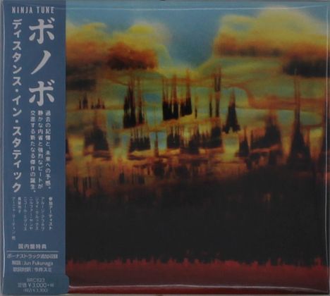 Text links: "Ninja Tune", japanische Schriftzeichen. Hintergrund: Verschwommen, abstrakte Landschaft in Braun- und Blautönen.