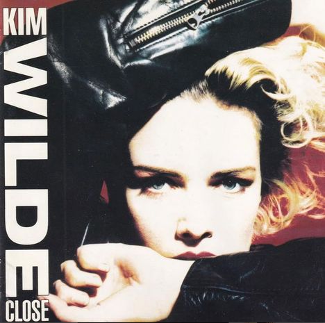 Text: "KIM WILDE CLOSE". 
Frau mit gebleichtem Haar, in Lederjacke, schaut intensiv nach vorne.