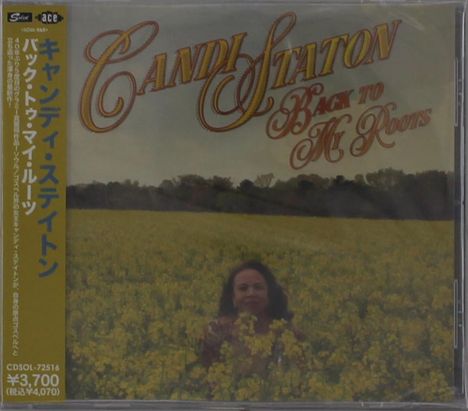 Der Text lautet: "Candi Staton Back to My Roots." Eine Person steht in einem blühenden, gelben Feld.