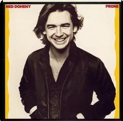 Der Text "Ned Doheny Prone" erscheint oben. Ein Mann lächelt in Schwarz-Weiß, seine Hände in den Taschen seiner Jacke.