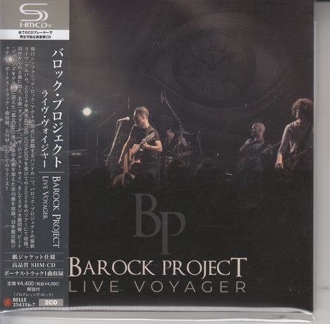 Texte: Barock Project Live Voyager. Szene: Band spielt live, Gitarren, Mikrofone, große Uhr im Hintergrund.