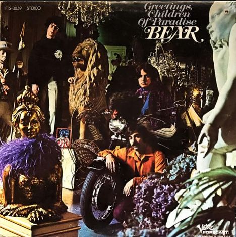 „Greetings, Children of Paradise BEAR“. Mehrere Personen in einem Raum mit Statuen, einem Löwen und opulenter Dekoration.