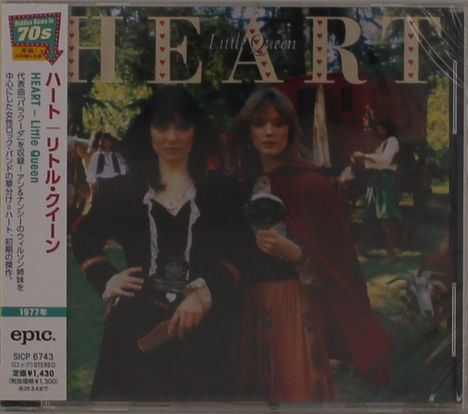 Zwei Frauen in mittelalterlicher Kleidung stehen draußen, umgeben von Bäumen. Text: "HEART Little Queen".