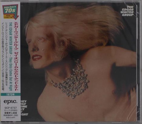 "The Edgar Winter Group" in der Ecke. Ein Mann mit langen weißen Haaren und glänzender Halskette auf dunklem Hintergrund.