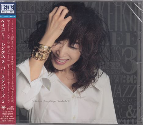 Eine Person lächelt mit geschlossenen Augen. Auf ihrem Handgelenk sind viele Armbänder. Text: "Keiko Lee | Sings Super Standards 3".