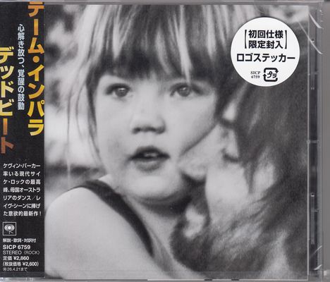 Japanische Schriftzeichen, darunter ein Kreis mit weiteren Zeichen. Schwarz-weiß Foto eines kleinen Kindes, nah aufgenommen.