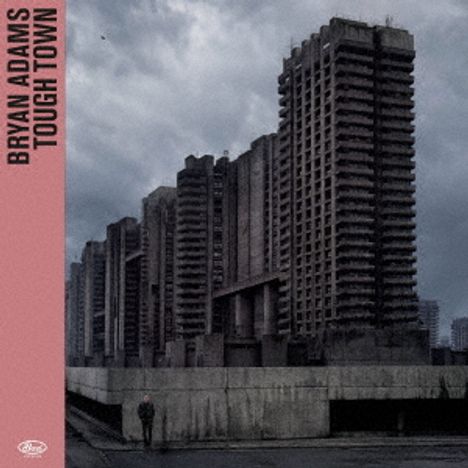 "BRYAN ADAMS TOUGH TOWN" auf rosa Streifen. Hochhäuser bei düsterem Himmel, Mensch in der Vorderansicht.