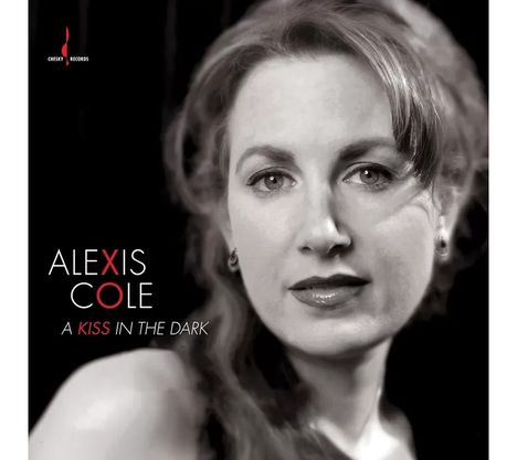 Text: „ALEXIS COLE, A KISS IN THE DARK“. Schwarz-weißes Porträt einer Frau mit ausdrucksvollem Blick.