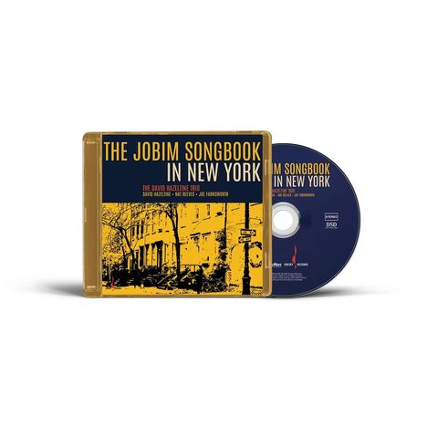 Auf der CD-Hülle steht "THE JOBIM SONGBOOK IN NEW YORK" von "THE DAVID HAZELTINE TRIO". Cover zeigt gelbes Stadtbild.