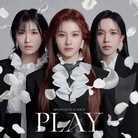 „MISAMO JAPAN 1st ALBUM PLAY“. Drei Personen in schwarzen Anzügen mit Rüschen, umgeben von fallenden Blütenblättern.