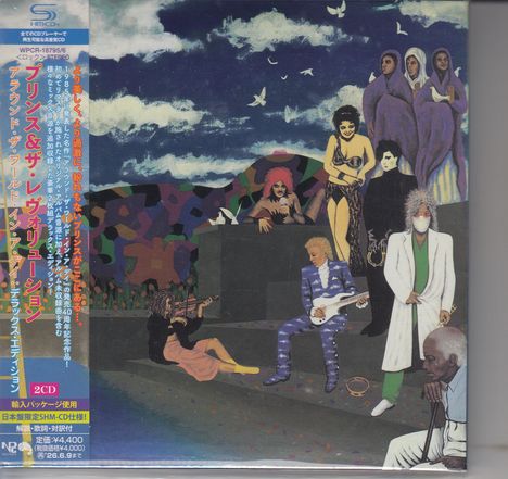 Japanischer Text links. Mehrere Menschen in bunter Kleidung, einige mit Instrumenten, vor einer bewölkten Szenerie.