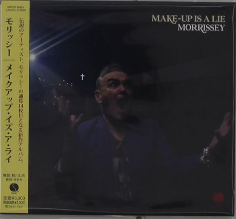 "MAKE-UP IS A LIE MORRISSEY" steht in der rechten Ecke. Links vertikaler japanischer Text. Eine Person in dunkler Umgebung.