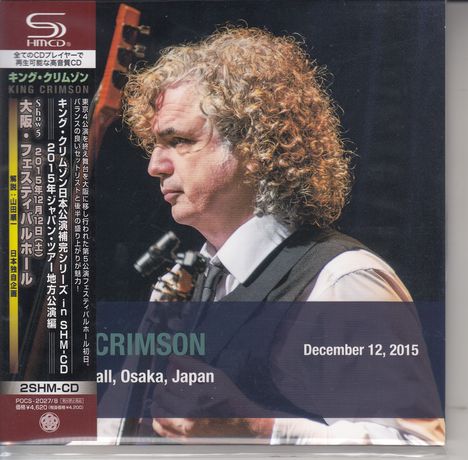"King Crimson", "Festival Hall, Osaka, Japan", "December 12, 2015". Ein Mann mit lockigen Haaren hält eine Gitarre.