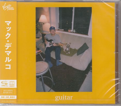 Eine Person sitzt auf einem Sofa mit einer Gitarre, daneben ein kleiner Hund. Japanische Schriftzeichen und "guitar".
