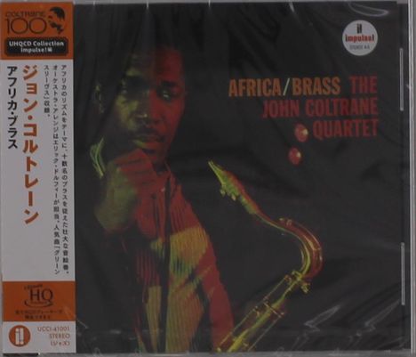 Text: "AFRICA/BRASS THE JOHN COLTRANE QUARTET". Japanische Schriftzeichen links. Jazzmusiker mit Saxophon, dunkler Hintergrund.