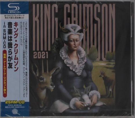 "King Crimson 2021" in großen Buchstaben. Illustration: Frau hält ein Kaninchen, umgeben von Tieren in einer Landschaft.