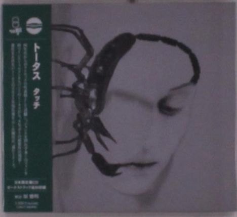 Japanische Schriftzeichen und englischer Text links. Ein Gesicht mit einer großen schwarzen, skorpionartigen Zeichnung rechts.