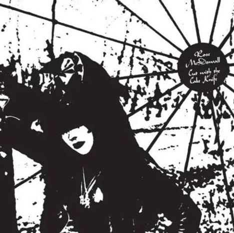 Text: "Rose McDowall. Cut with the Cake Knife." Schwarz-weißes, kontrastreiches Bild mit stilisierter Person und geometrischem Hintergrund.