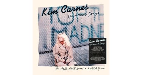 Kim Carnes, Uncovered Songs. The A&M, EMI America & MCA Years. Frau sitzt vor Zaun, trägt beigen Mantel.