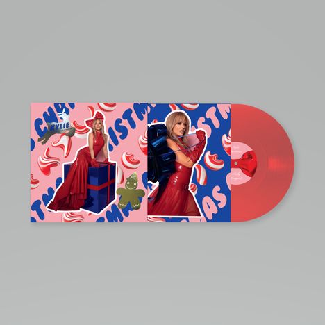 "Kylie Christmas" in blauen Buchstaben auf rosa Hintergrund. Zwei Bilder von einer Frau in rotem Kleid neben rotem Vinyl.