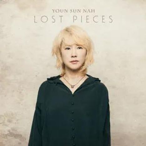 "Youn Sun Nah, Lost Pieces." Eine Frau mit blondem Haar in dunkler Kleidung vor einem schlichten, hellen Hintergrund.