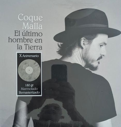 „Coque Malla: El último hombre en la Tierra“, „X Aniversario 180 gr Marmolado Remasterizado“. Ein Mann im Profil mit Hut.