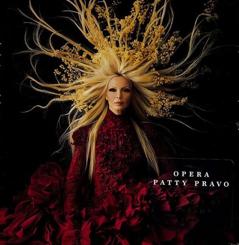 Text: "OPERA PATTY PRAVO". Frau in rotem Kleid mit langen Haaren und floralen Elementen, dramatische Darstellung.