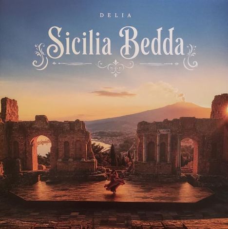 Text: „Delia Sicilia Bedda“. Ruinen mit Tanzender im Vordergrund, Vulkan in der Ferne bei Sonnenuntergang.