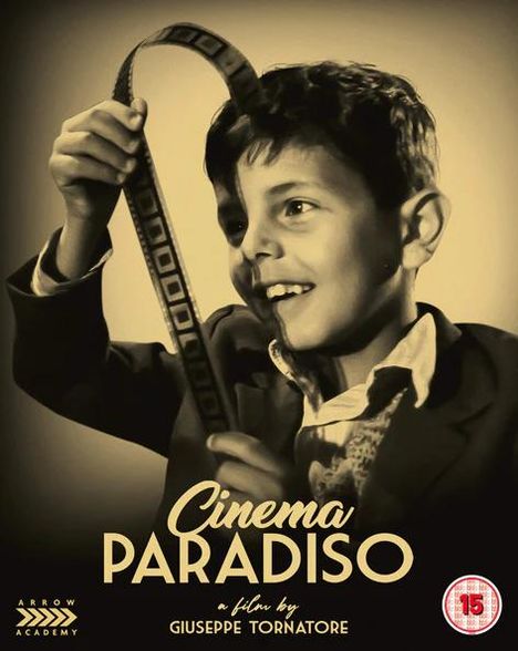 „Cinema Paradiso“, ein Film von Giuseppe Tornatore. Ein Junge hält einen Filmstreifen und lächelt begeistert.
