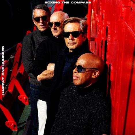 "BOXING THE COMPASS" oben, "HAIRCUT ONE HUNDRED" links. Vier Männer mit Sonnenbrillen vor einer roten Wand.
