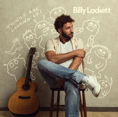 Text: "Things are looking up!" und "Billy Lockett". Mann sitzt auf einem Stuhl, umgeben von gezeichneten Figuren, daneben Gitarre.