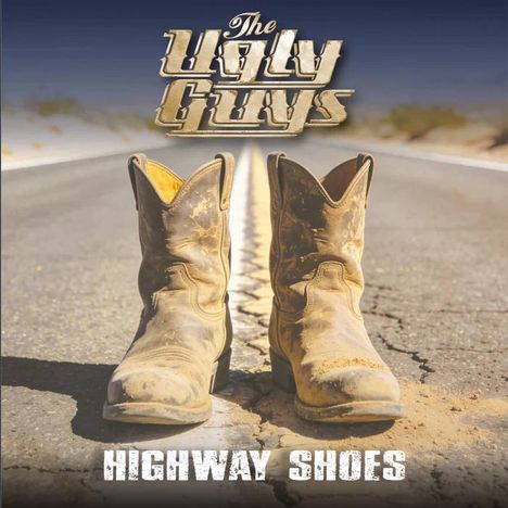 "The Ugly Guys" oben, "Highway Shoes" unten. Zwei schmutzige Cowboy-Stiefel stehen auf einer Straße mit Mittelstreifen.