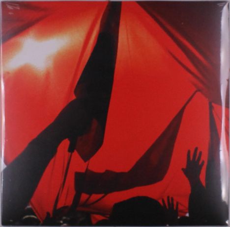 Menschen heben Hände und schwenken Fahnen unter rotem Licht, Silhouetten betonen die Bewegungen dramatic.