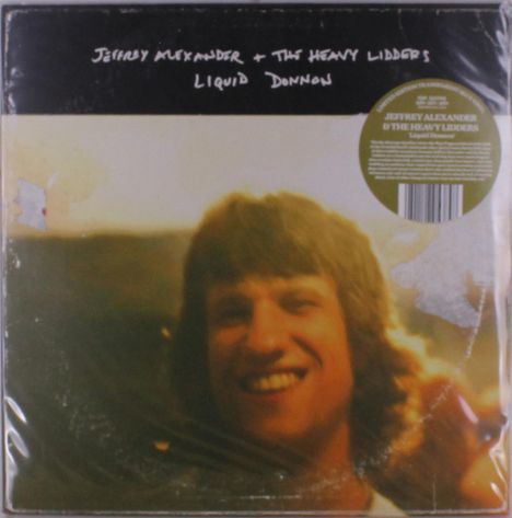 Text: "Jeffrey Alexander & The Heavy Lidders, Liquid Diamonds." Ein lächelnder Mann im Hintergrund verschwommen.