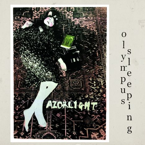 Der Text "olympus sleeping" und "RAZORLIGHT". Eine Person liegt auf einem orientalischen Teppich mit Büchern daneben.
