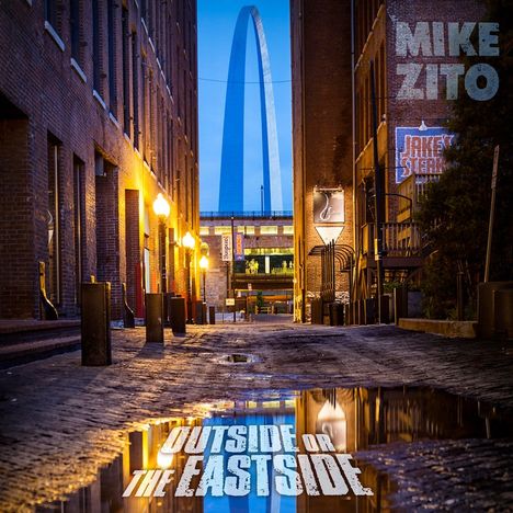 Texte: "MIKE ZITO", "OUTSIDE OR THE EASTSIDE". Eine schmale Gasse mit Backsteinwänden, im Hintergrund ein großer Bogen.