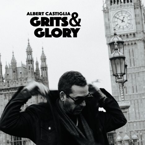 Albert Castiglia, Grits & Glory. Ein Mann mit Sonnenbrille vor dem Big Ben und anderen historischen Gebäuden.