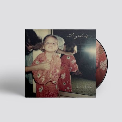 Text: "Long live Home" und "Jesca Hoop". Ein Kind in einem roten gemusterten Gewand schaut in die Kamera, daneben ein Spiegel.