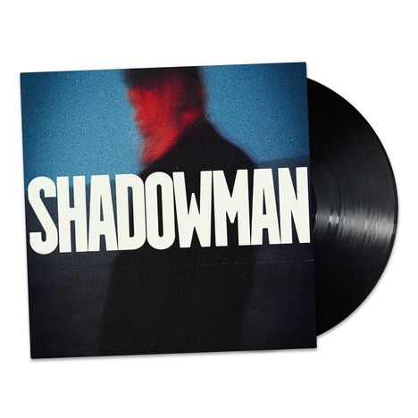 "SHADOWMAN" steht groß auf einem Albumcover. Ein unscharfer, rotblauer Schattenriss eines Mannes ist im Hintergrund.