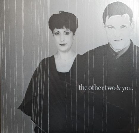 Text: "the other two & you." Zwei Personen in Schwarz-Weiß, nebeneinander, mit Linien im Vordergrund.