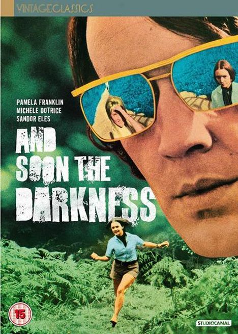 Text: "AND SOON THE DARKNESS". Eine Frau läuft durch Farn, reflektiert in Sonnenbrillen auf einem Gesicht.