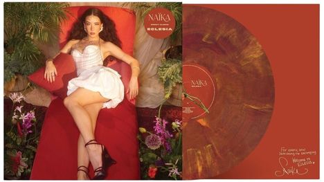"NAÏKA DEBUT ALBUM ECLESIA" ist in Großbuchstaben auf einem rot-braunen Hintergrund. Eine Frau liegt in einem weißen Kleid auf einem roten Sofa, umgeben von Pflanzen.